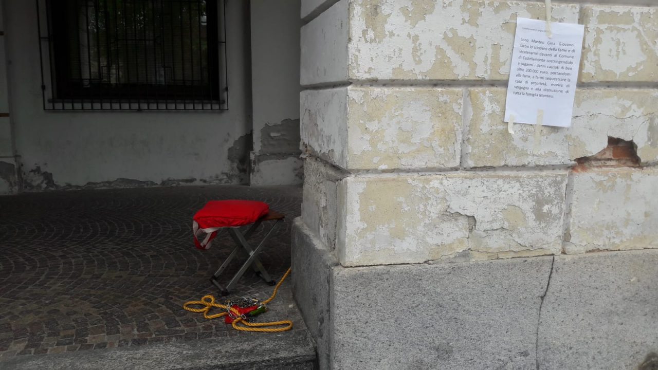 Si incatena davanti al Comune di Castellamonte: “Aiutatemi, sono alla fame!” | FOTO