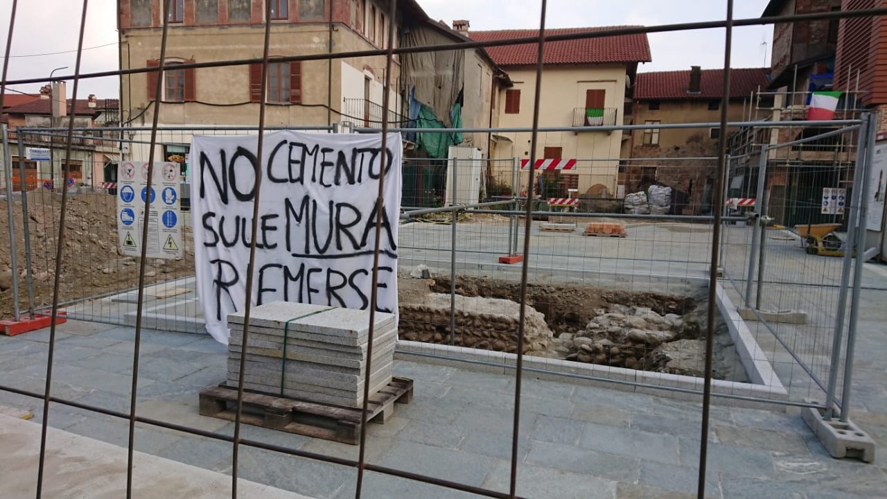 Nole, mura medievali scoperte in piazza. E intanto appare anche uno striscione…