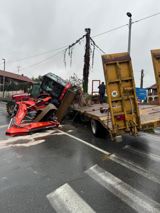 Incidente sulla statale 26 a Candia: escavatore cade dal rimorchio e si ribalta in strada