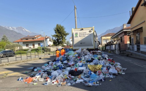 Camion della spazzatura perde il carico di rifiuti in strada