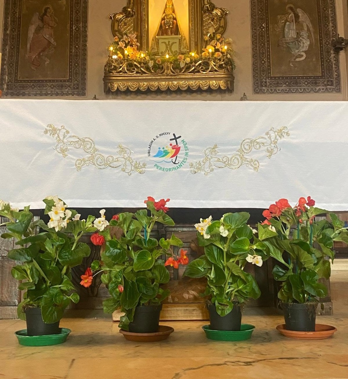 In ricordo dei frati aggrediti, fiori bianchi e rossi al convento
